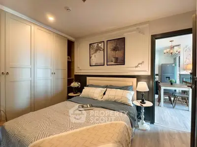 Cozy bedroom with elegant decor and view into a stylish dining area, perfect for modern living.