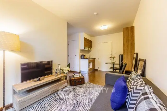 Modern living room with stylish decor and open kitchen layout in a cozy apartment.
