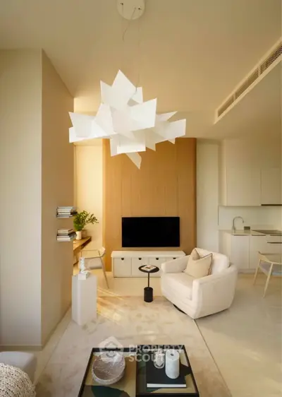Modern living room with stylish chandelier and cozy seating area, featuring a sleek TV setup and elegant decor.