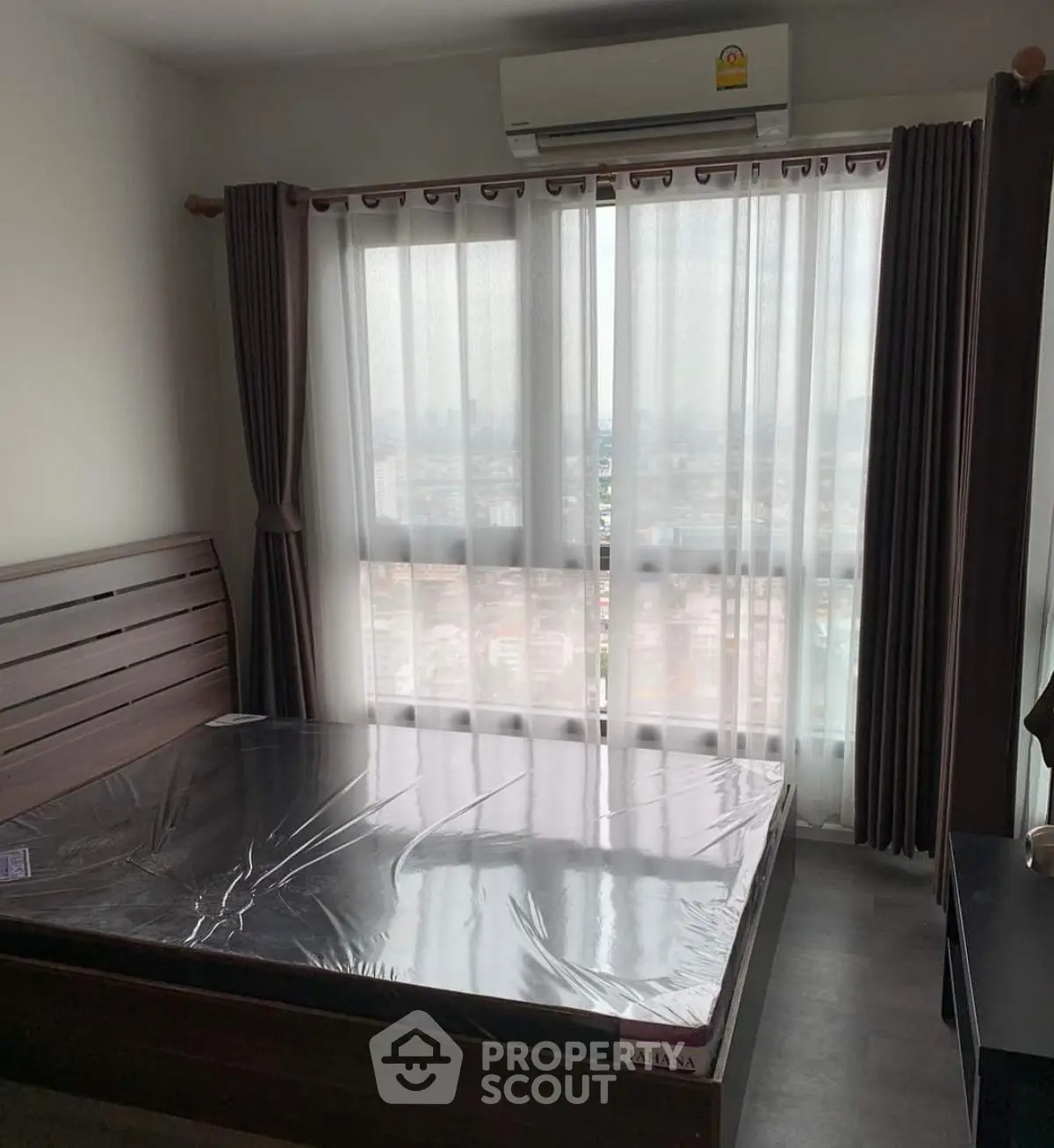 Modern bedroom with large window and city view, featuring sleek wooden bed frame and air conditioning.