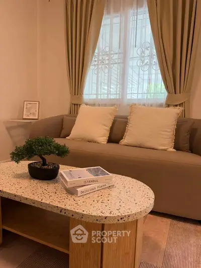 Cozy living room with elegant sofa, stylish coffee table, and decorative accents for a warm ambiance.