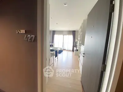 Modern apartment entrance leading to a stylish living room with natural light and elegant decor.