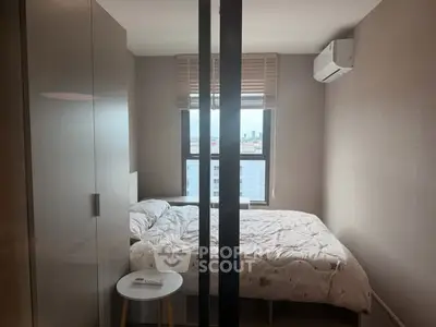 Cozy bedroom with city view, featuring a comfortable bed and air conditioning.