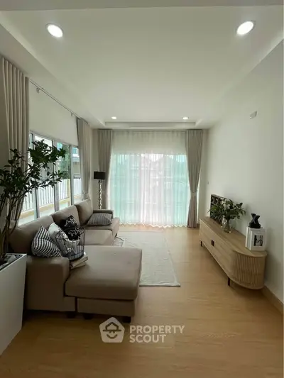 Spacious living room with modern decor and large windows for natural light.