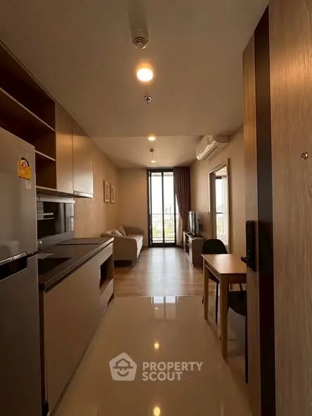 Modern apartment interior with open kitchen and cozy living area, featuring sleek design and natural light.