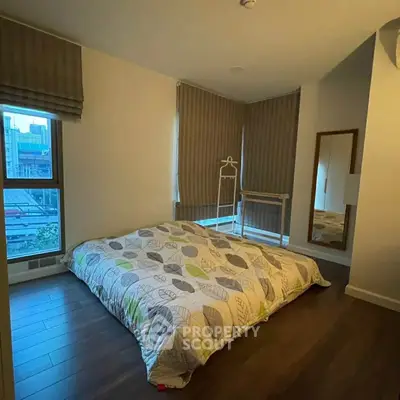 Cozy bedroom with large windows and modern decor in urban apartment