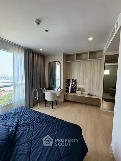 Modern bedroom with city view, featuring sleek furniture and natural light.