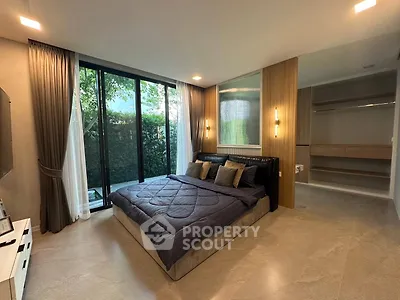 Luxurious bedroom with large windows and modern decor, featuring a spacious walk-in closet.