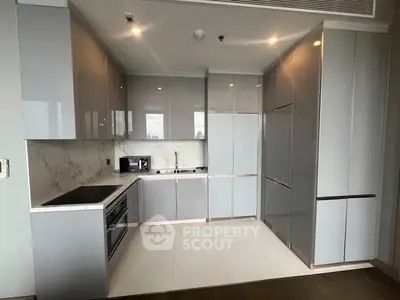 Modern kitchen with sleek cabinetry and built-in appliances in luxury apartment.