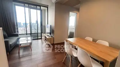 Modern living room with city view, sleek furniture, and wooden flooring in a high-rise apartment.