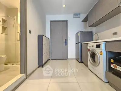 Modern apartment entryway with washing machine and sleek cabinetry