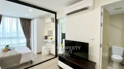 Modern apartment interior with bedroom and living area, featuring sleek design and natural light.
