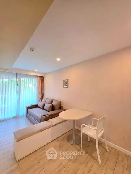 Modern living room with cozy sofa and dining area, featuring large windows and elegant decor.
