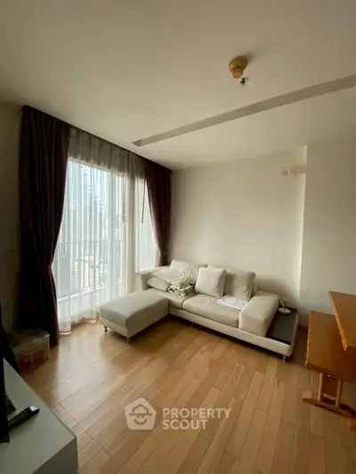 Bright living room with wooden flooring and large window in modern apartment