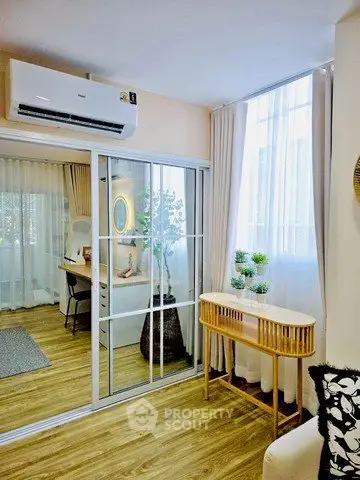 Modern living room with stylish decor and natural light, featuring a sleek air conditioner and elegant wooden flooring.