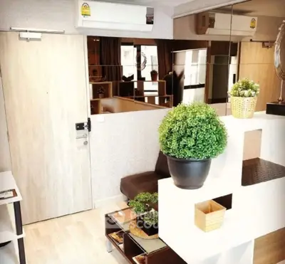 Modern living room with stylish decor and indoor plants, featuring a cozy seating area and mirrored wall.