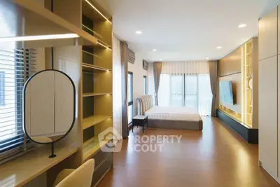 Spacious modern bedroom with elegant decor and large windows for natural light.