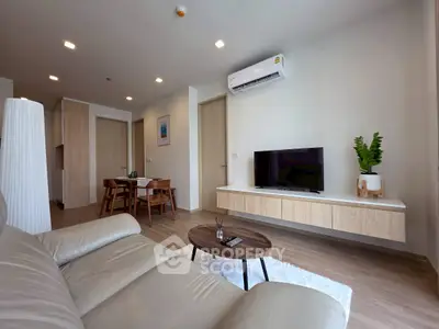 Modern living room with sleek furniture and wall-mounted TV in a stylish apartment.