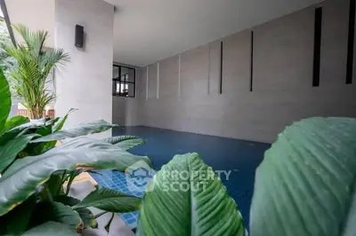 Modern indoor pool area with stylish design and lush greenery
