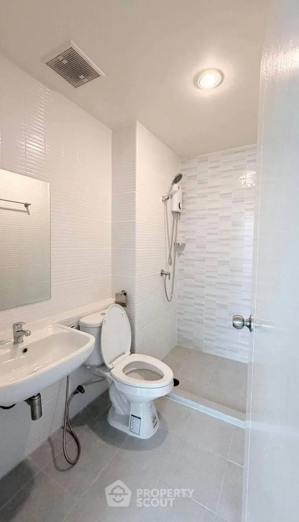 Modern minimalist bathroom with sleek white tiles and shower area