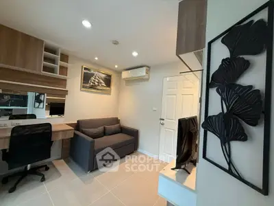 Modern living room with sleek furniture and wall art, featuring a cozy sofa and a flat-screen TV.