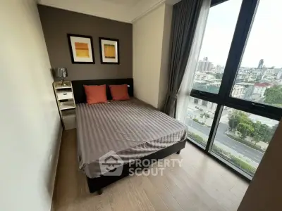 Modern bedroom with large window offering city view, featuring stylish decor and cozy ambiance.