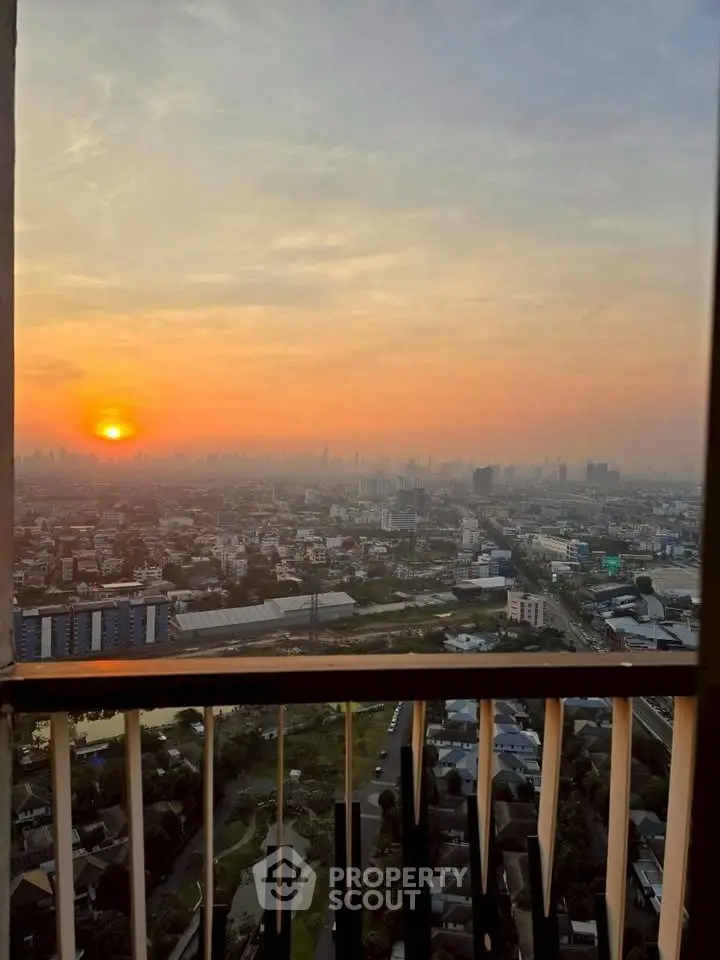 Stunning sunset view from a high-rise balcony overlooking the city skyline.