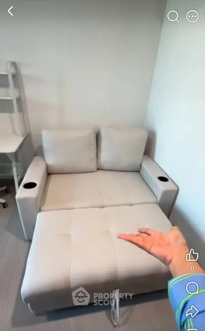 Modern living room with stylish sofa bed and sleek desk, perfect for compact spaces.