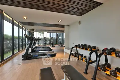 Modern gym with state-of-the-art equipment and panoramic windows in luxury residential building.