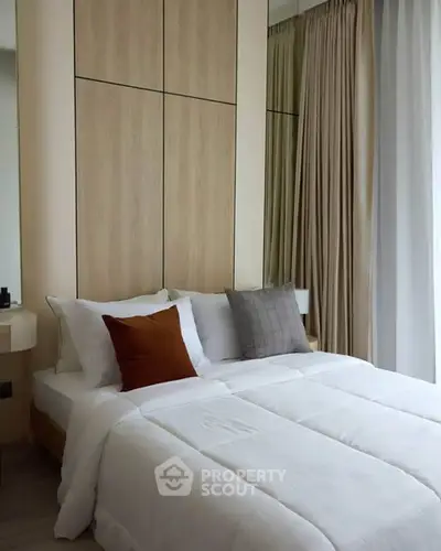 Modern bedroom with cozy bedding and elegant curtains in a stylish apartment.