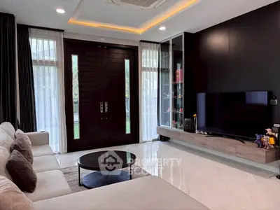 Modern living room with sleek design, large TV, and elegant furniture