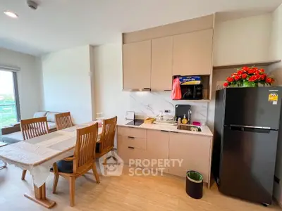 Modern kitchen and dining area with sleek cabinets and cozy seating.
