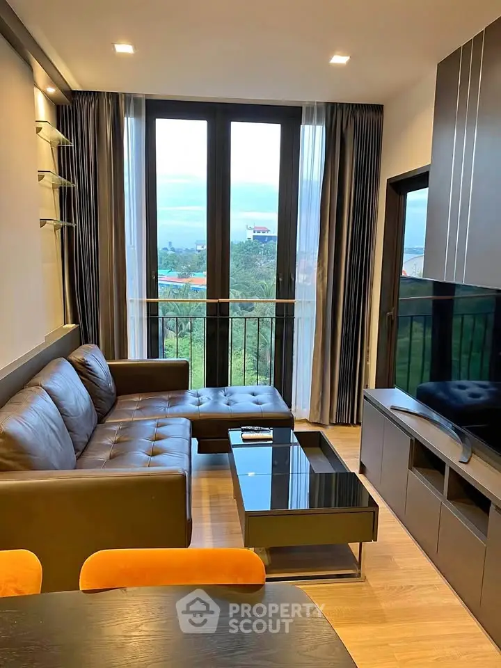 Modern living room with large windows and stylish furniture, offering a cozy and inviting atmosphere.