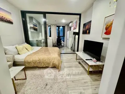 Modern studio apartment with stylish decor and open layout, featuring a cozy bed and sleek TV setup.