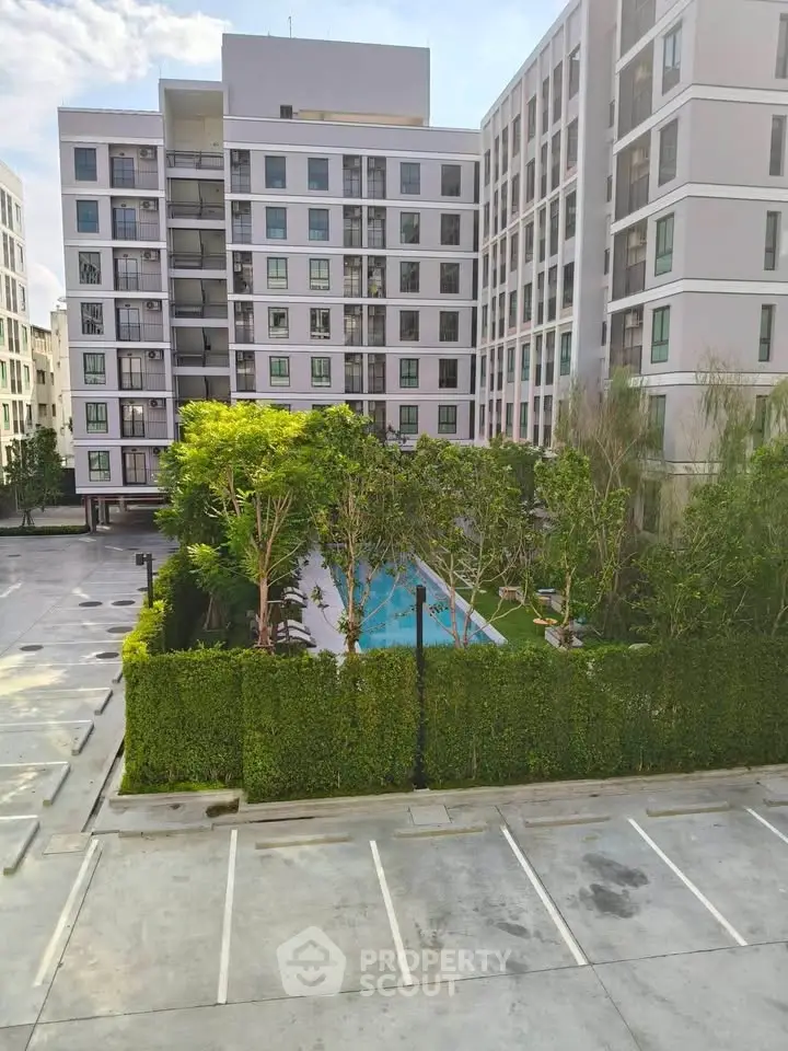 Modern apartment complex with pool and lush greenery in urban setting