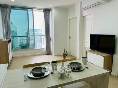 Modern living room with dining area and city view, featuring sleek furniture and natural light.