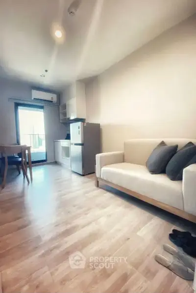 Modern living room with open kitchen and cozy seating area, perfect for urban living.