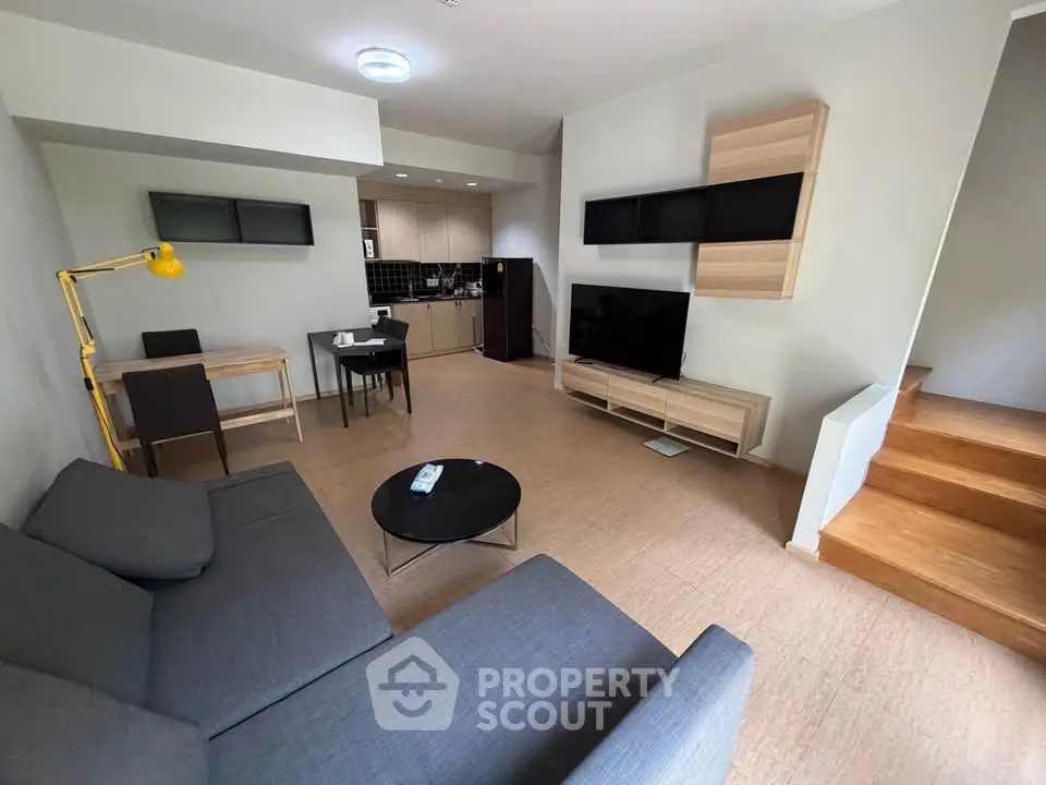 Modern open-plan living room with stylish furniture and integrated kitchen area, perfect for contemporary living.