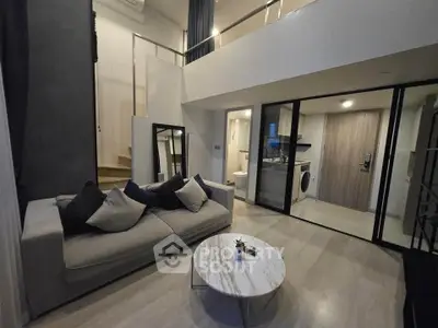 Modern duplex living room with stylish decor and open layout, featuring a cozy sofa and elegant marble coffee table.