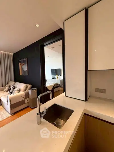 Modern open-plan living room and kitchen with sleek design and cozy ambiance.