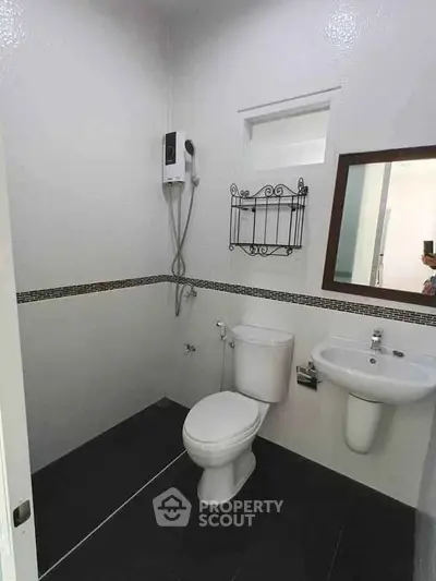 Modern minimalist bathroom with sleek fixtures and wall-mounted shower.