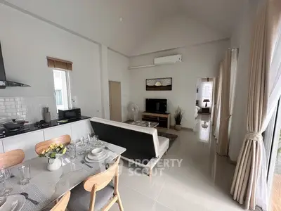 Modern open-plan living room with dining area and sleek kitchen in a bright, airy apartment.