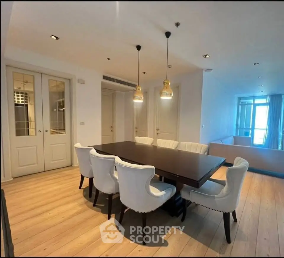 Elegant dining area with modern lighting and spacious seating in a stylish apartment.
