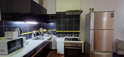 Modern kitchen with sleek black cabinets and stainless steel appliances