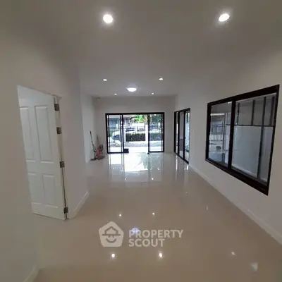 Spacious living room with glossy tiled floors and large windows offering ample natural light.