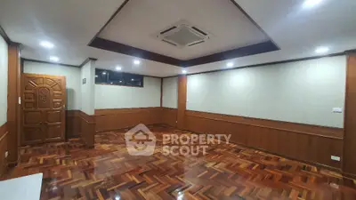 Spacious empty room with wooden flooring and ceiling air conditioning