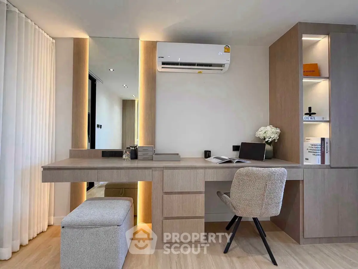 Modern study room with sleek desk, stylish chair, and built-in storage in a contemporary apartment.