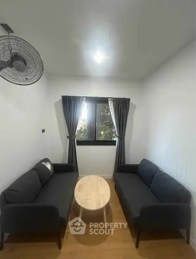 Cozy living room with modern sofas and wooden coffee table, perfect for relaxation.