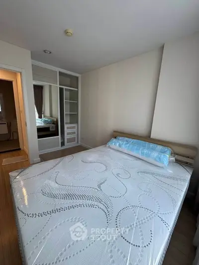 Spacious bedroom with modern design and ample storage in a stylish apartment.