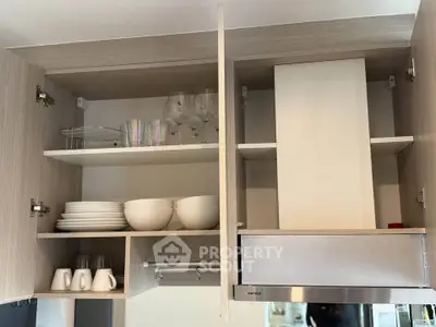 Modern kitchen cabinet with open shelves displaying dishes and glasses, showcasing sleek design and ample storage.